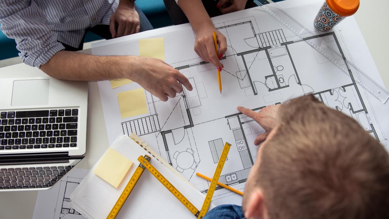 Équipe travaillant ensemble sur les plans d’un projet architectural
